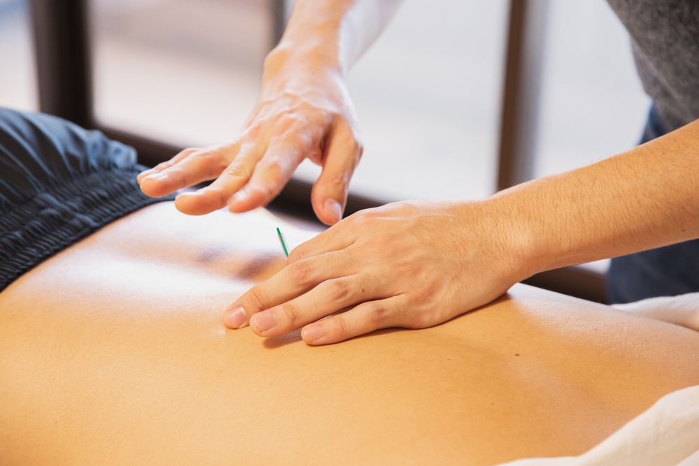 Therapist working on tension across the back and shoulders