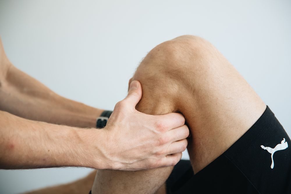 Therapist applying deep pressure to the leg muscles