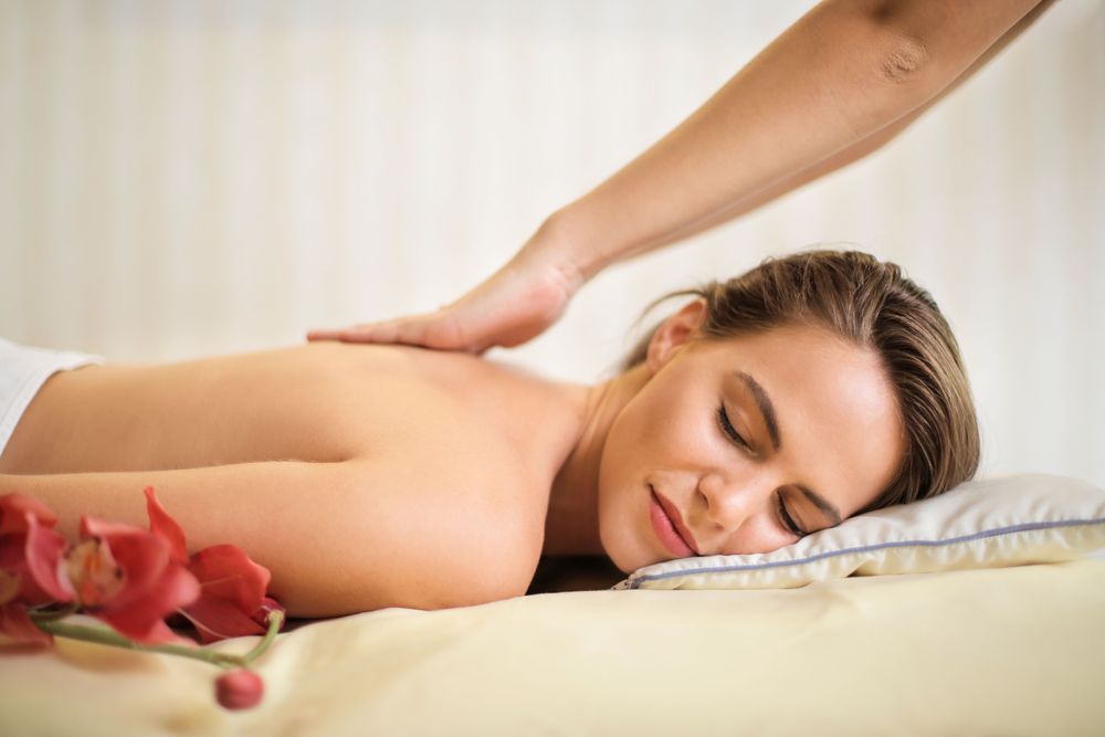 Flowing palm strokes along the back during an Italian massage
