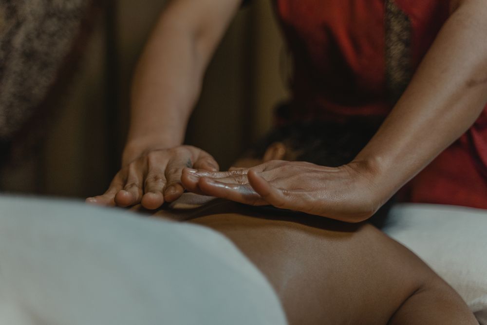 Client receiving a full body massage on a draped treatment table