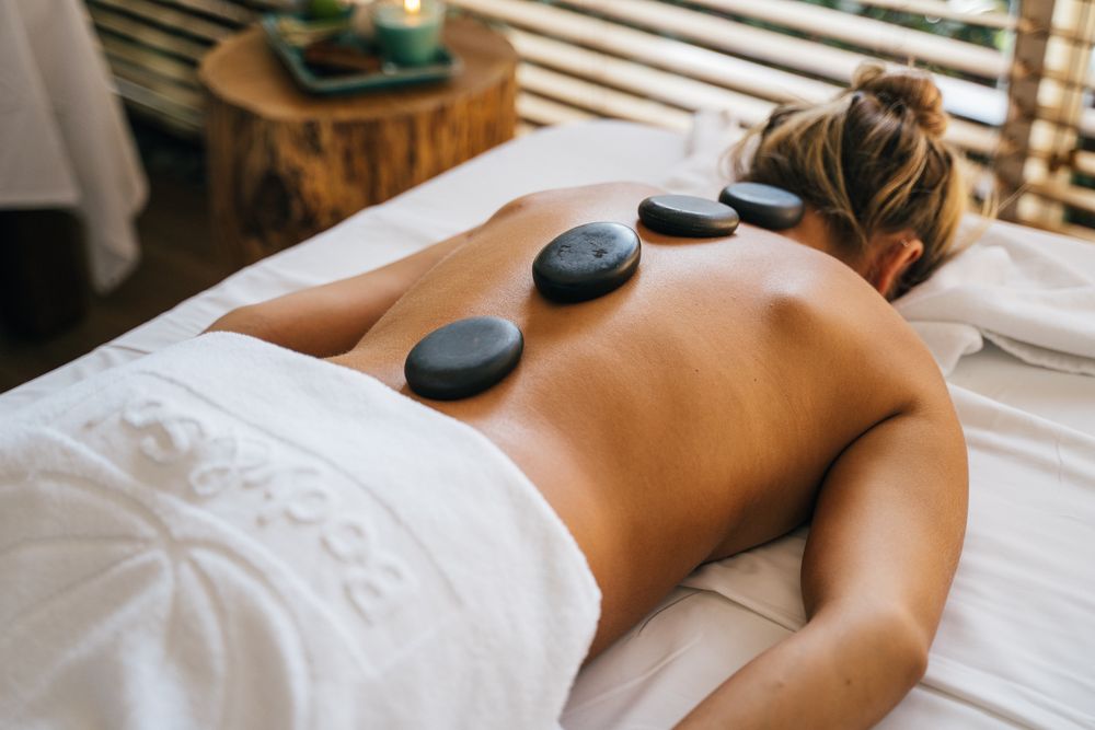 Hot stone therapy session with basalt stones on the back