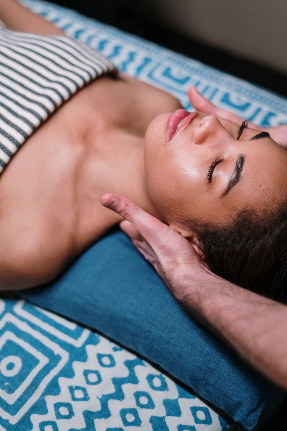 Woman relaxing as a therapist massages her neck and shoulders